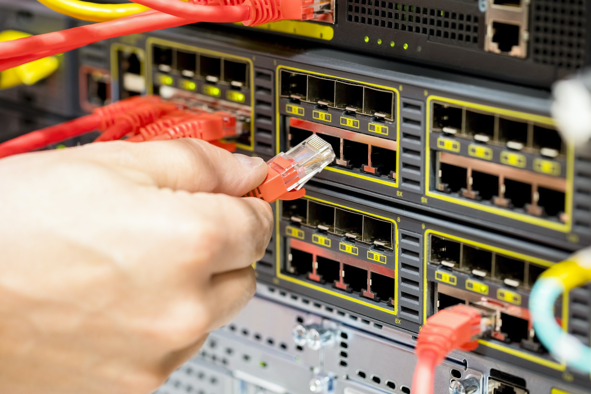 Hand Plugging Fiber Cable Into Switch In Datacenter