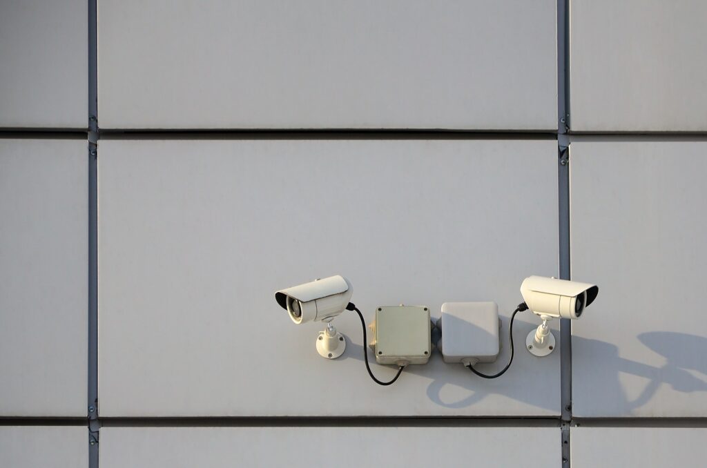 White surveillance camera built into the metal wall of the office building