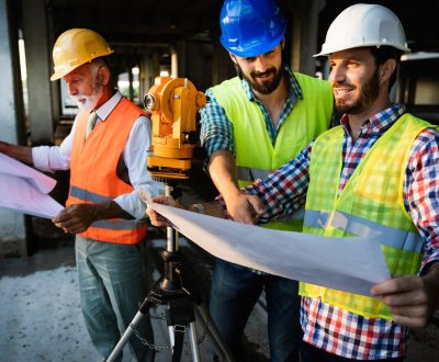 two-satisfied-engineers-talking-at-building-site-with-construction-structure-in-background.jpg